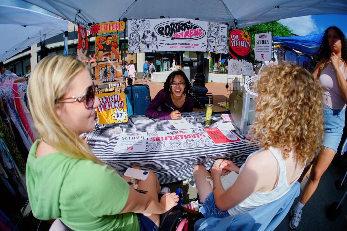 A caricature artist drawing visitors at Select Markets
